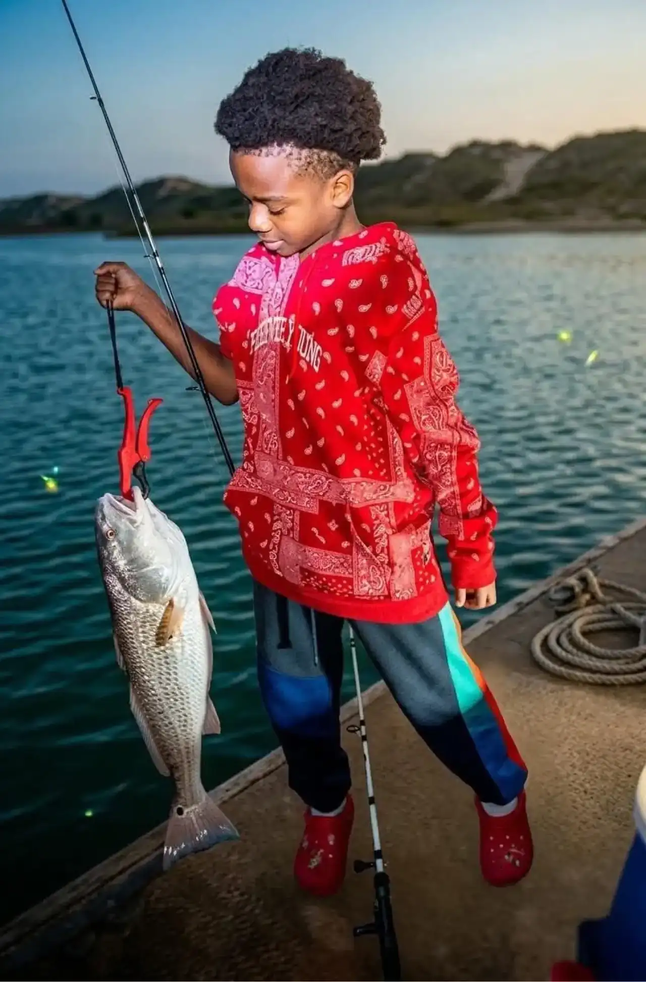 Saltwater Jointz Kid holding a redfish